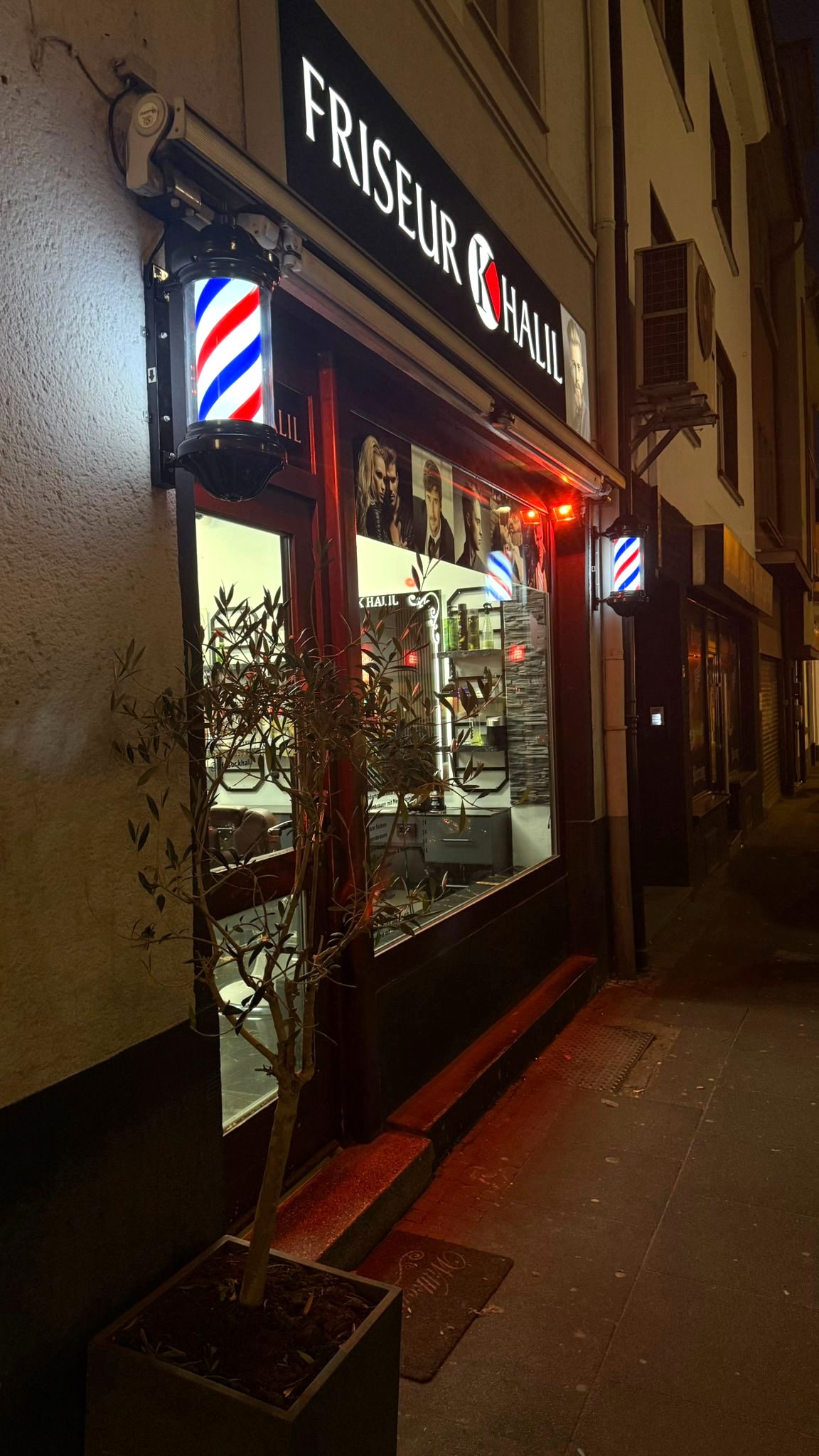 Der beleuchtete Eingang von Friseur Khalil in der Johannesstraße bei Nacht