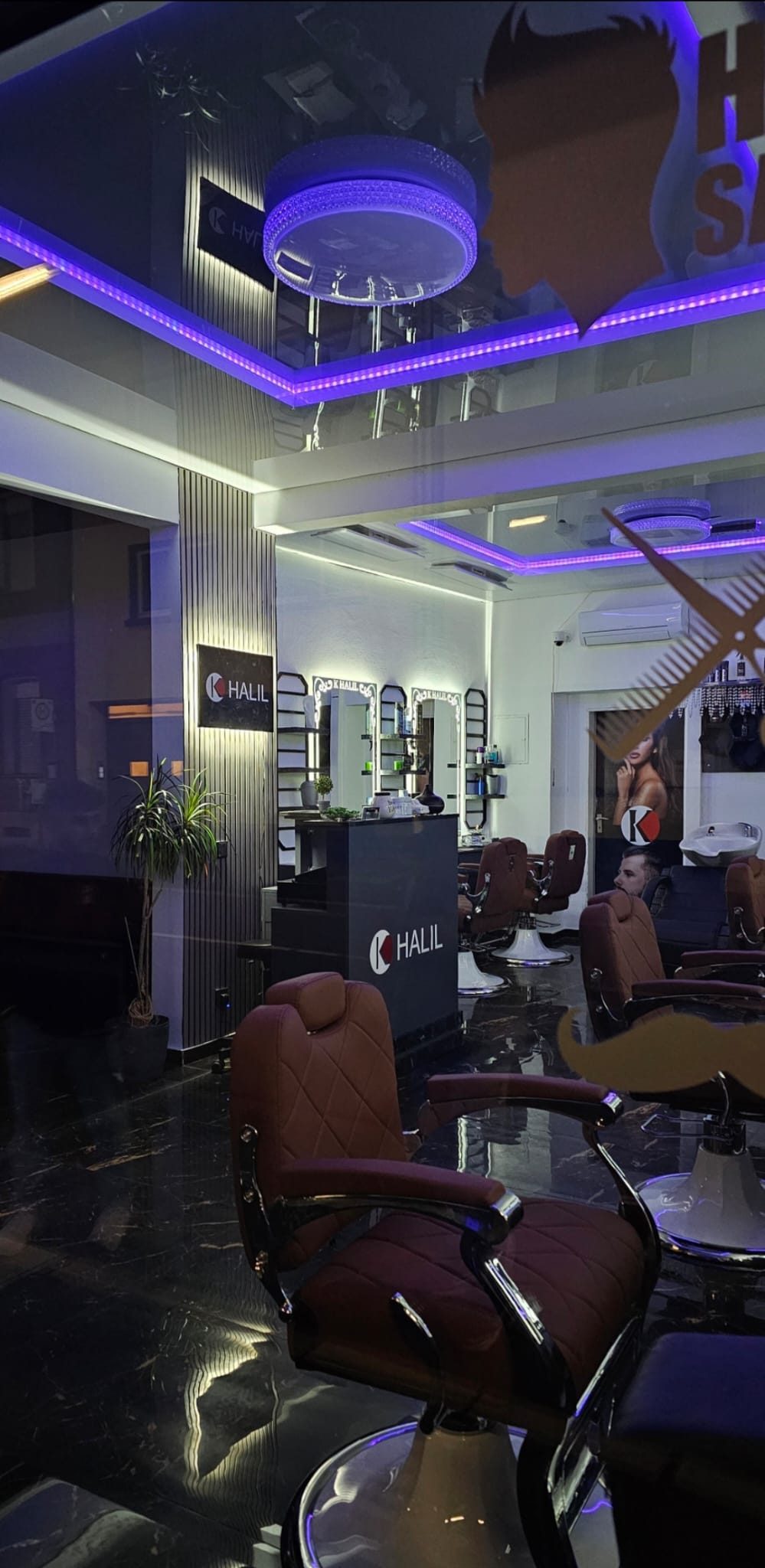 Blick in den Salon mit Empfangstresen und Barbierstühlen